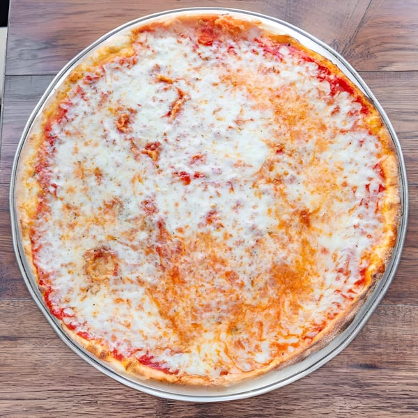 A classic New York-style cheese pizza with melted mozzarella and red sauce on a metal pan.
